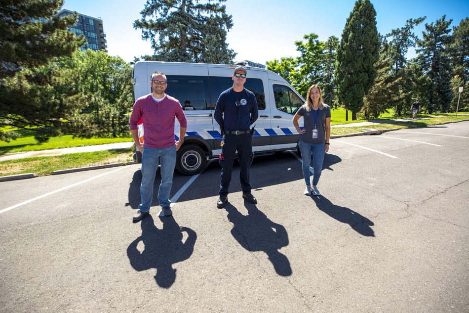 Chris Richardson and Carleigh Sailon with the Mental Health Center of Denver (left and right) and Spencer Lee, a Denver Health paramedic, stand in front of the Support Team Assisted Response's new van.