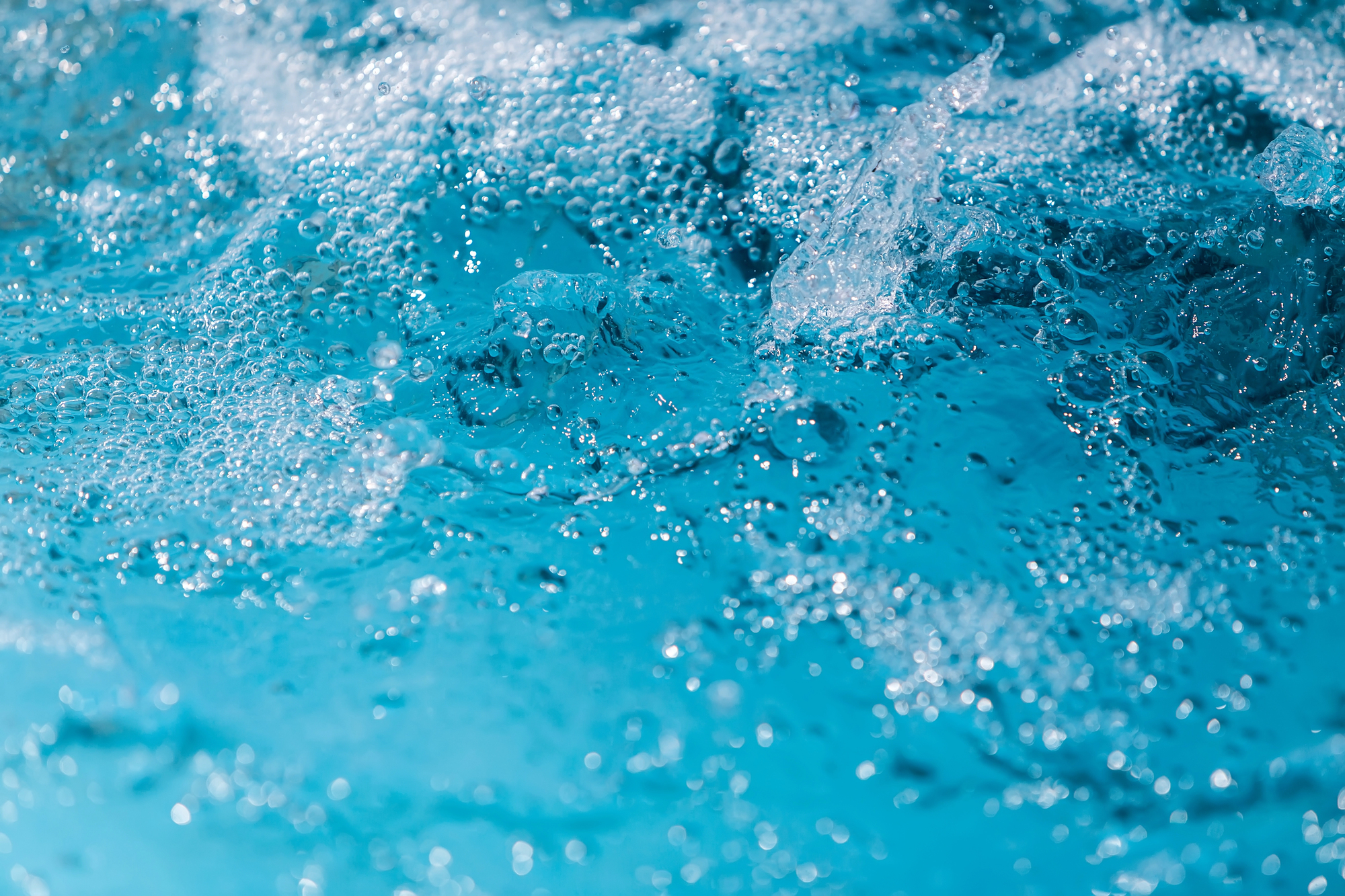 Close-up of turquoise water with bubbles and splashes in motion
