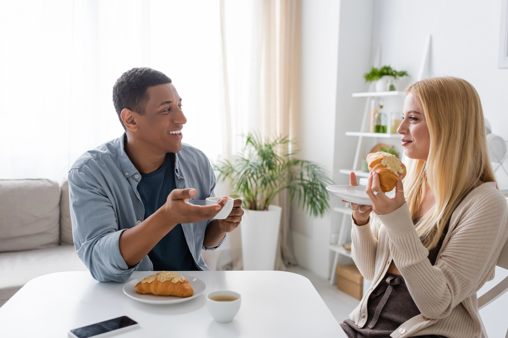 Two people sharing a meal together at a dinner table, illustrating the social physiology benefits of eating with companions on blood sugar regulation