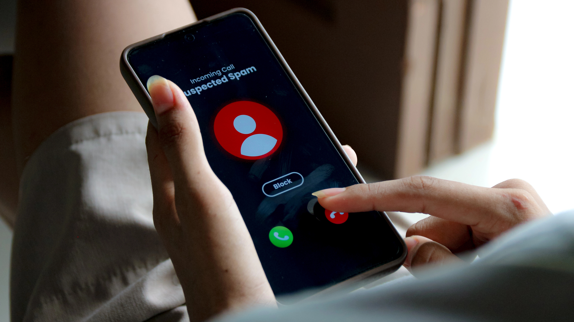 Person declining a phone call on their smartphone, representing France's new ban on unsolicited telemarketing and cold calls
