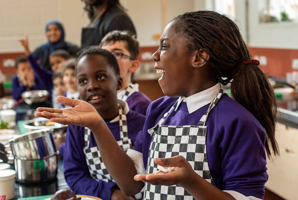 Diverse children happily learn how to cook with Chefs in Schools UK