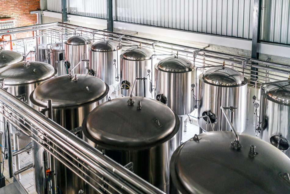 High angle view of metallic vats in brewery for precision fermentation.