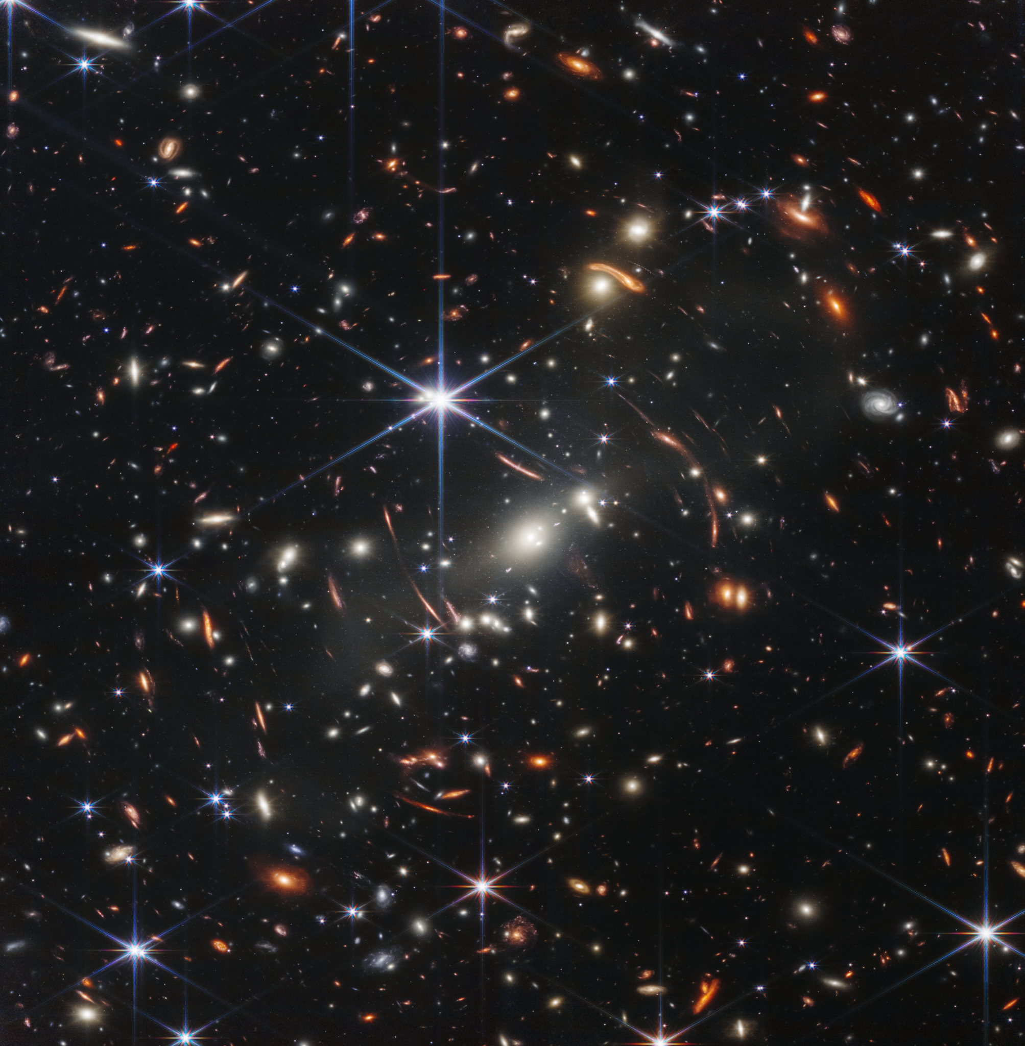 Deep-space field with countless galaxies and stars scattered across a dark sky.