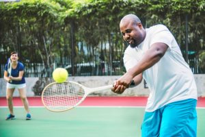 Couple playing tennis as a team