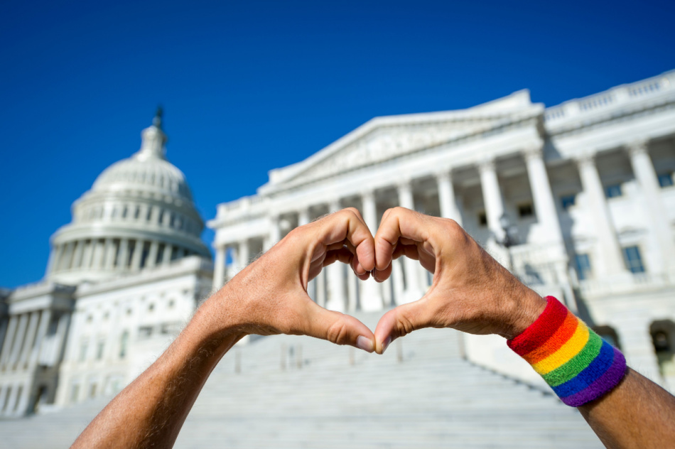 Happy fingers forming a hand heart on a bright sunny view of the Capitol Building in Washington, DC, USA
