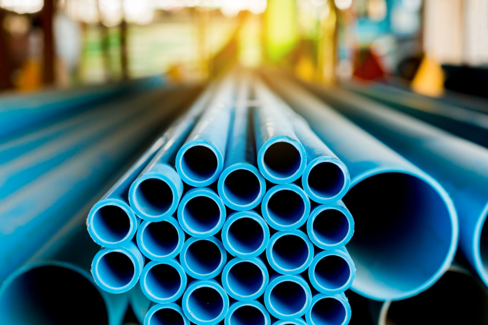 Close up to blue plastic pipe background, PVC pipes stacked in warehouse