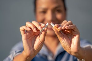 Beautiful woman happy to rip apart a cigarette