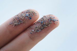 Close up side shot of microplastics lay on people hand.Concept of water pollution and global warming. Climate change idea.
