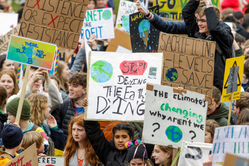 Bristol college students and schoolchildren carrying climate change placards and signs are pictured taking part in a climate change protest