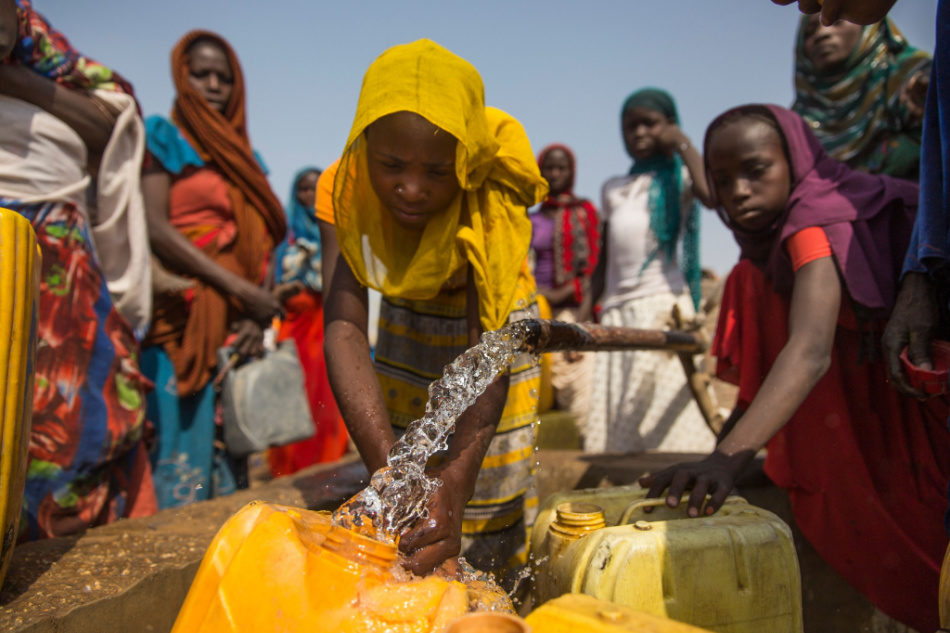 11 May 2019: Girls from Chad pour clean drinking water into a water bottle.