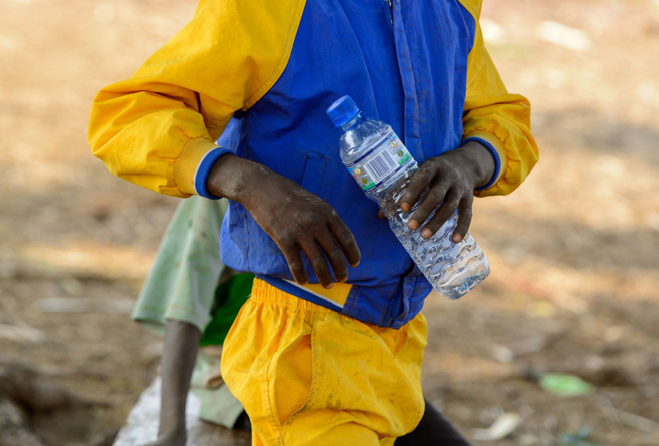 Unidentified little boy holds a plastic bottle