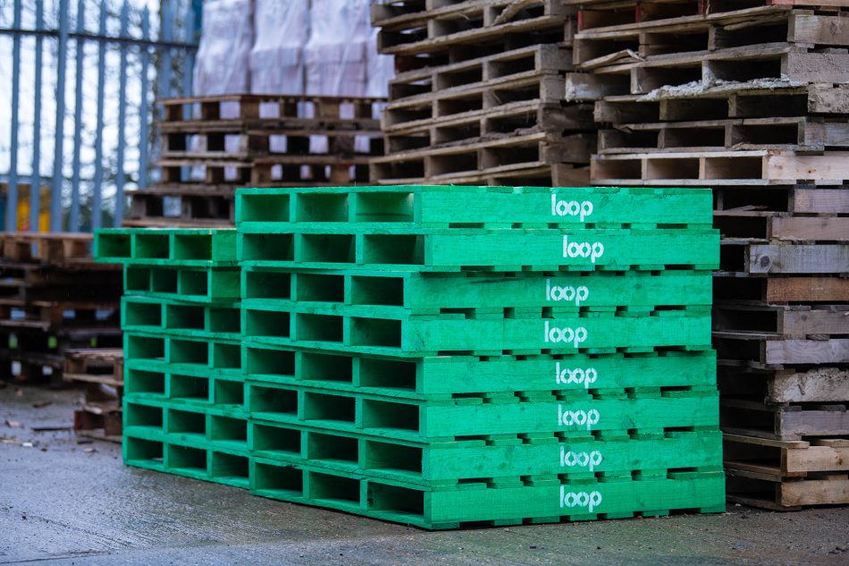 two stacks of the green reusable pallets from the Pallet LOOP system