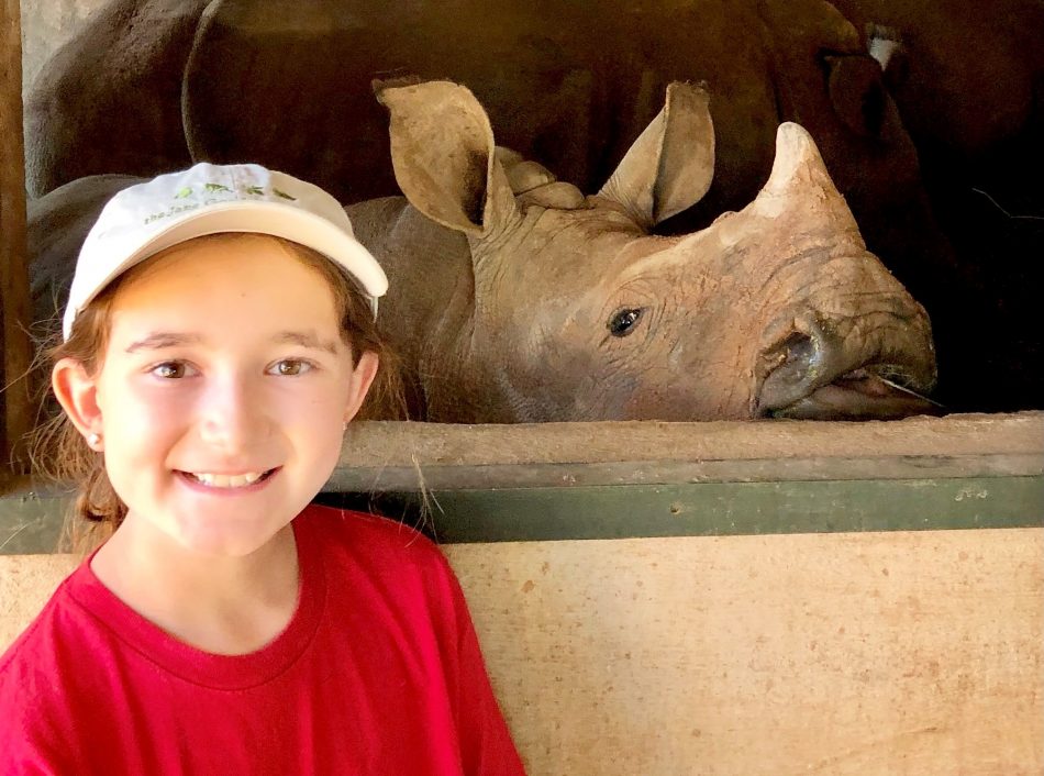 young wildlife conservationist Kate Gilman Williams stands in front of a rhino