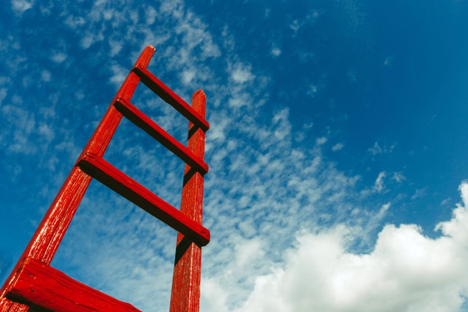 Red ladder against a cloudy blue sky