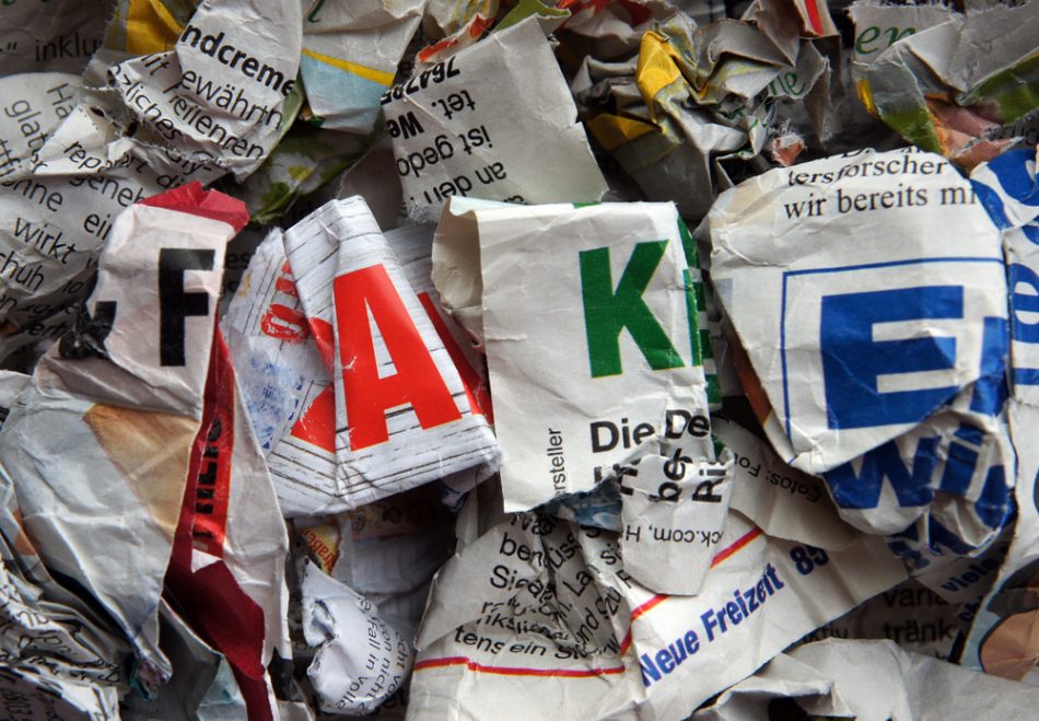 Crumpled newspapers that publish false news in different foreign languages are thrown out in the trash as an illustration of fake news.