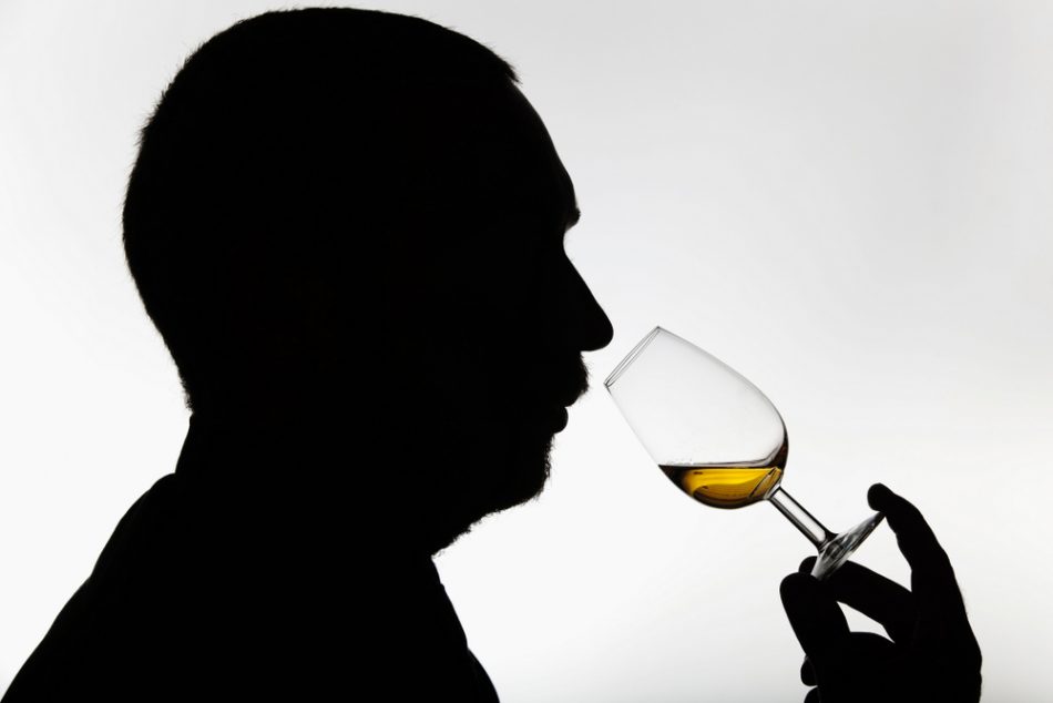 Silhouette of person smelling whisky.
