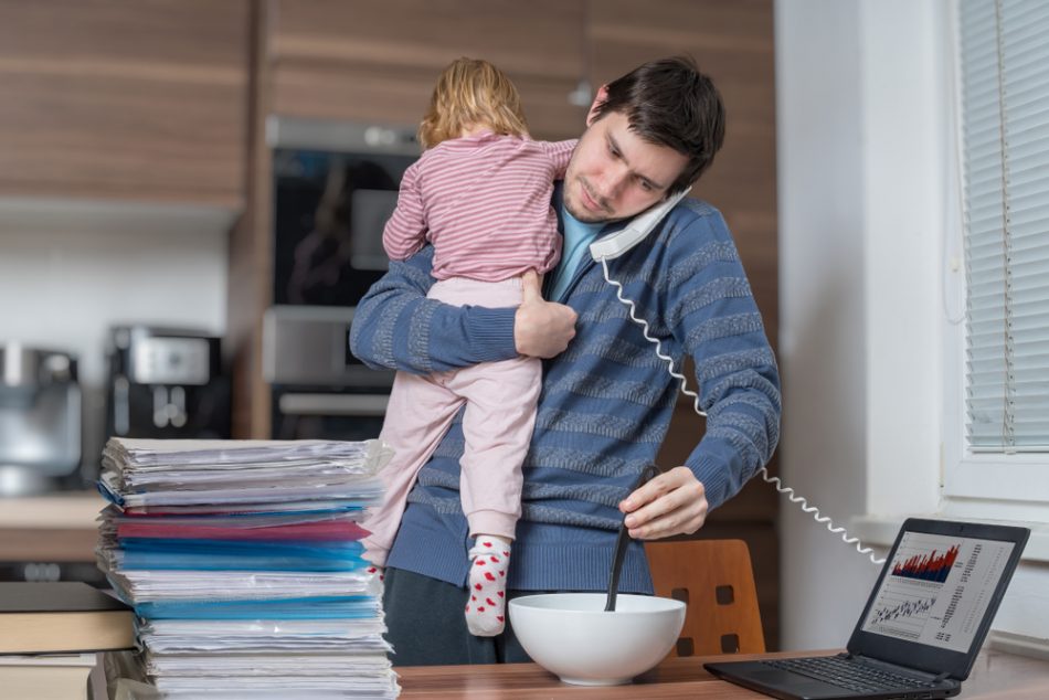 Father holding his child while making lunch