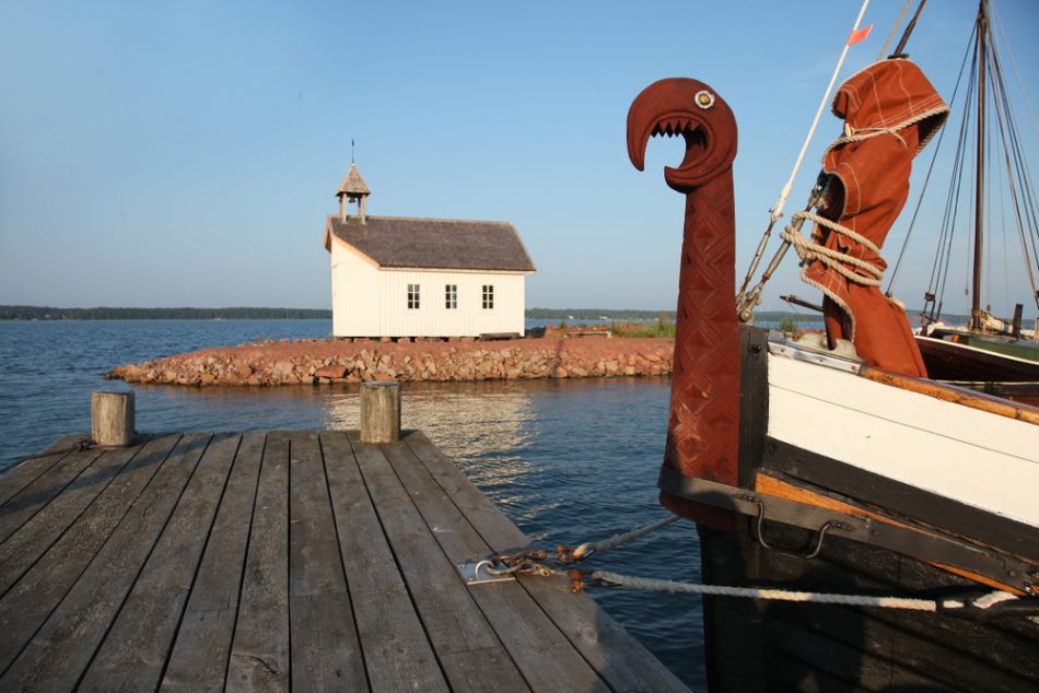 Old viking boat and white chapel in shipyard in Marienhamn on Aland islands.