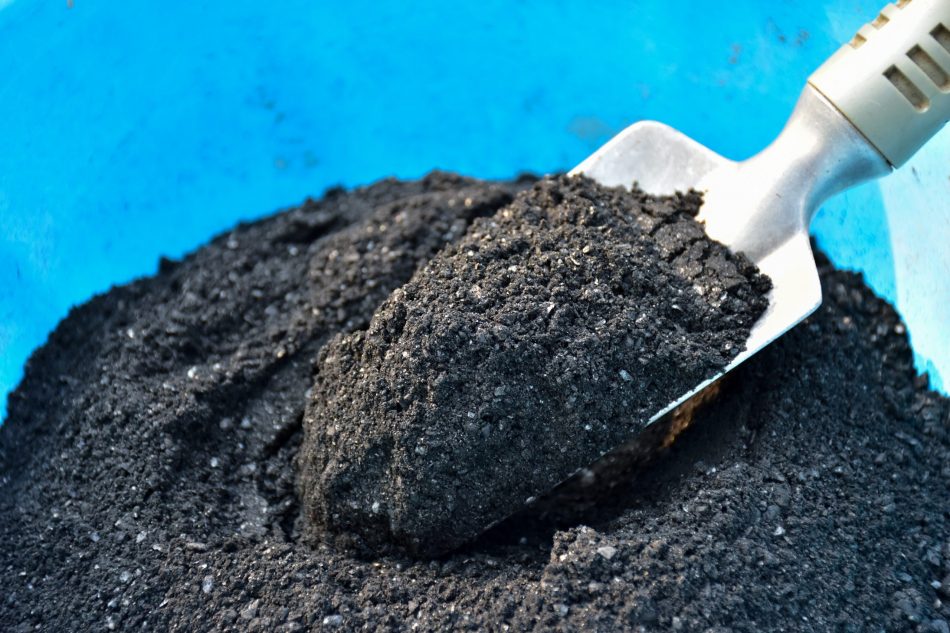 Shovel on charcoal (biochar) texture background for fertilizer. biochar powder