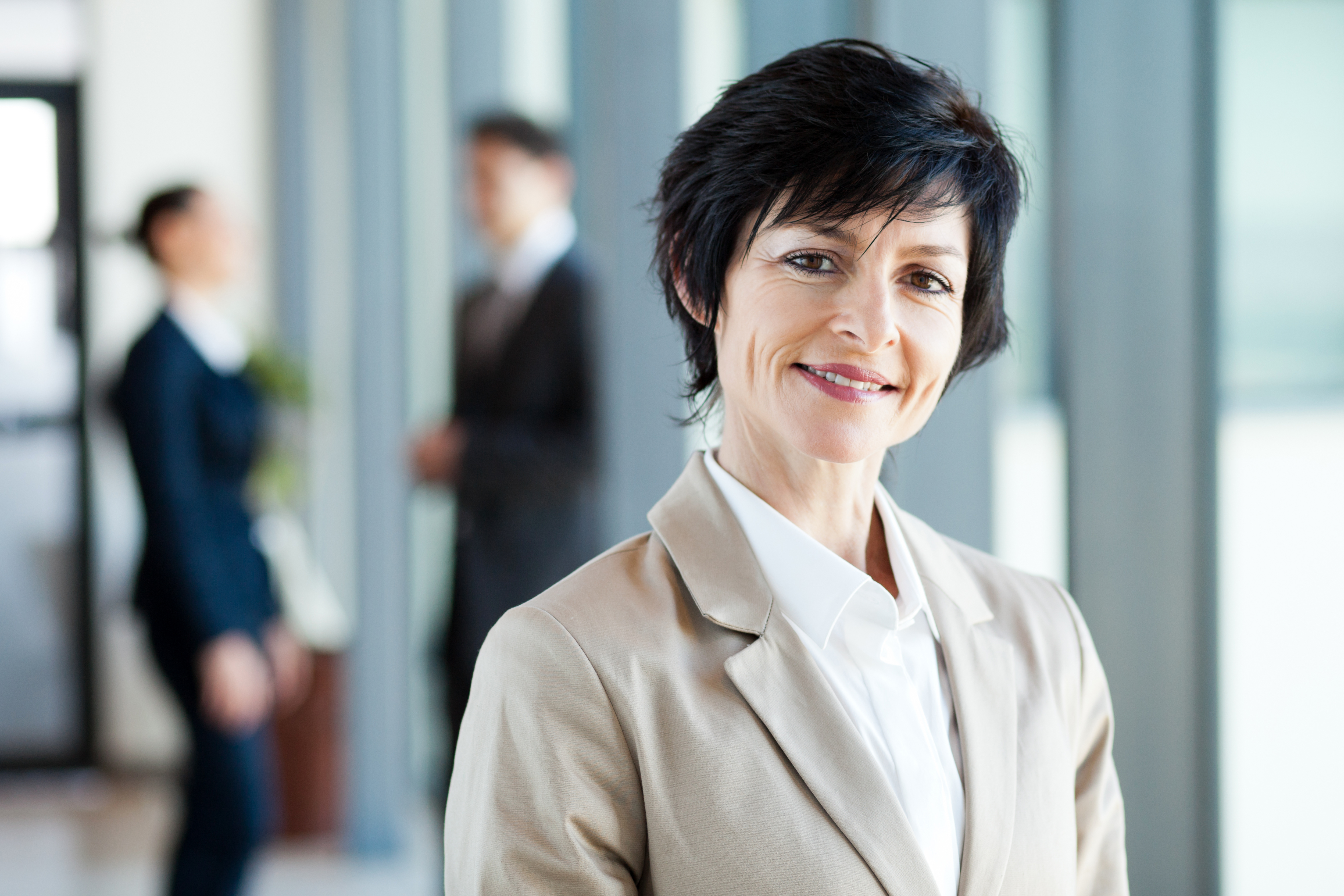 middle aged professional woman with black short hair smiles