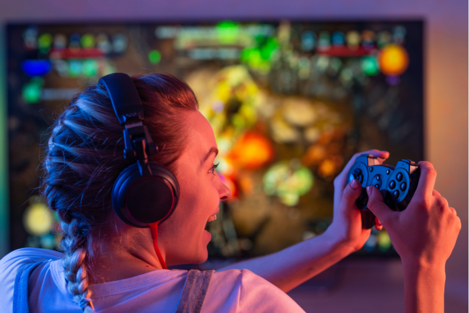 woman with braided hair enthusiastically plays video game