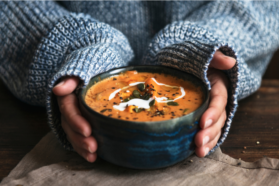 woman's hands around hot bowl of soup