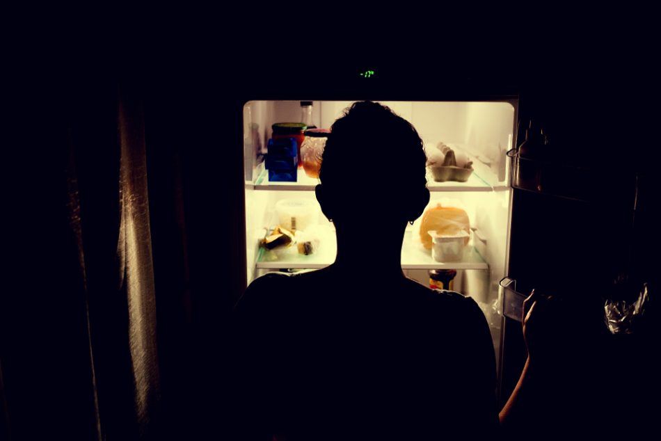 Person getting food at night from the fridge.