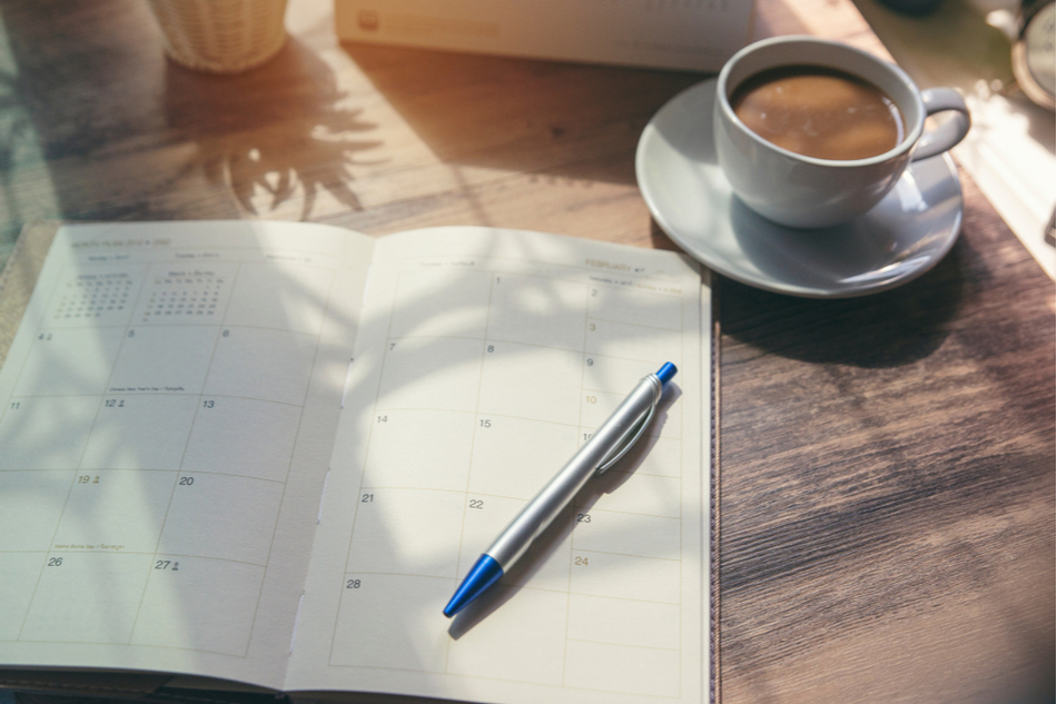 Productivity planner on the table next to a cup of coffee