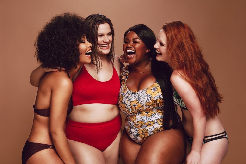 diverse group of four women laugh and smile together