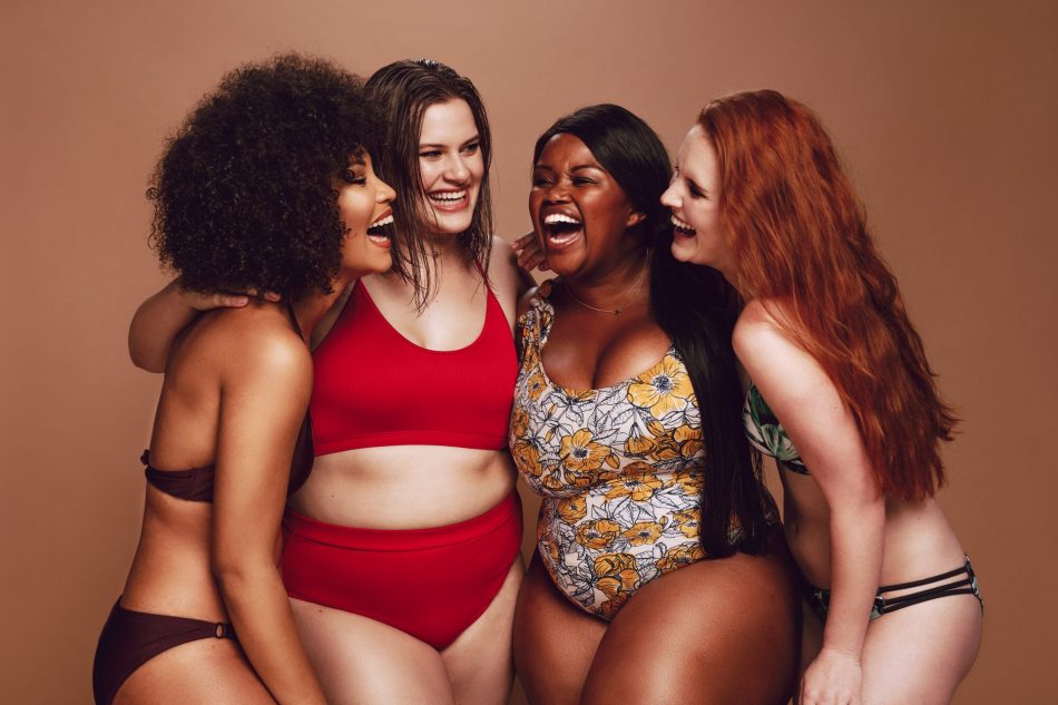 diverse group of four women laugh and smile together