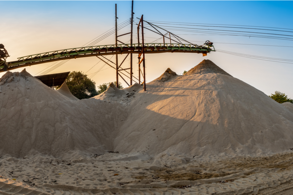 Sand piles next to industrial machinery