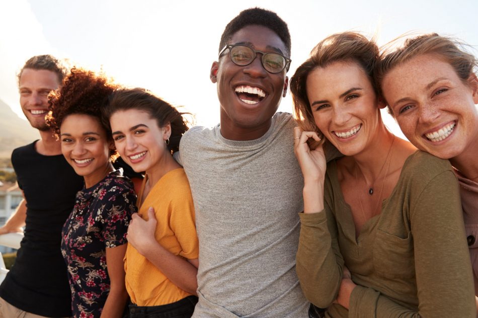 Portrait Of Smiling Young diverse Friends Walking Outdoors Together