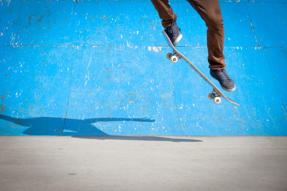Skater doing a ollie against a blue background