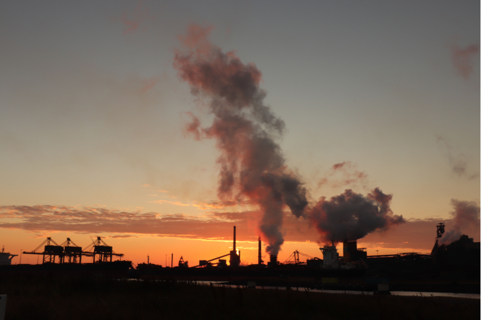 industrial skyline at dusk or dawn with lots of carbon emissions in the air