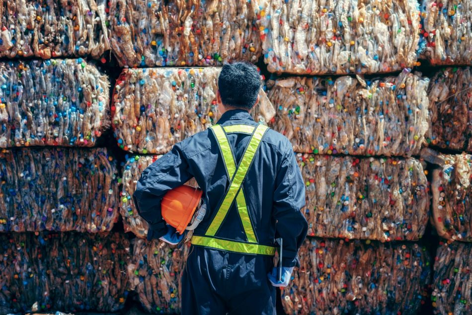 engineer stands in front of wall of plastic pollution