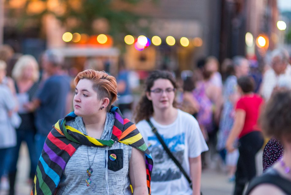 Young LGBTQ woman walks through crowd