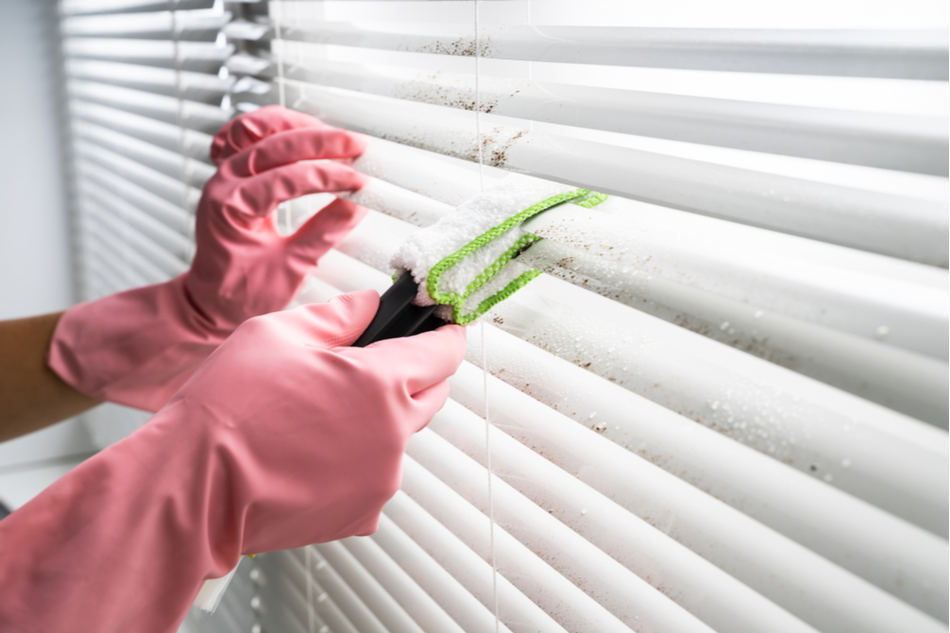 Cleaning dirty blinds with tongs and a cloth