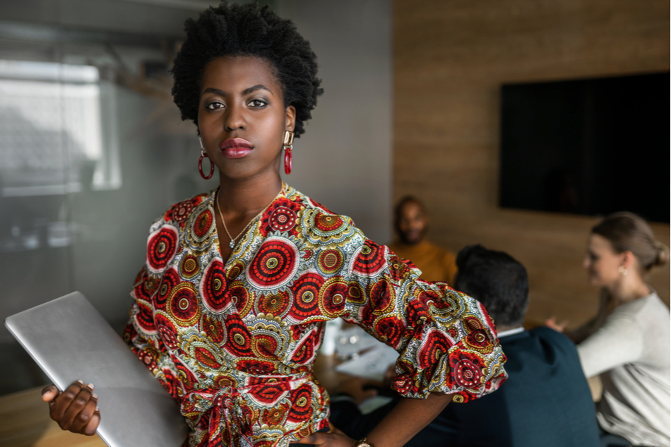 Strong black female entrepreneur CEO boss queen with natural hair stares authoritatively into camera