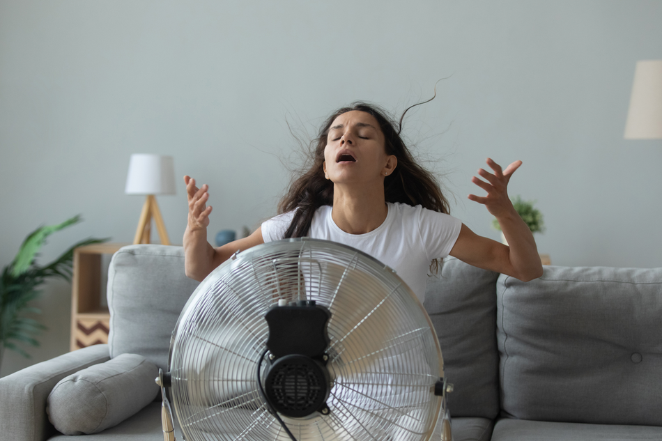 woman trying to cool down in front of a blasting fan