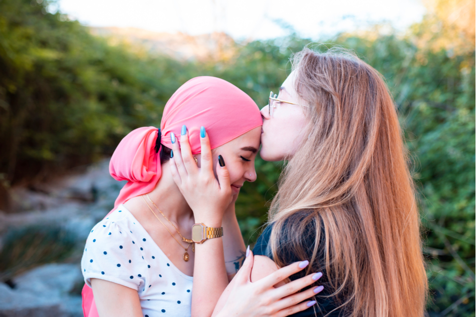 young cancer patient embraces friend