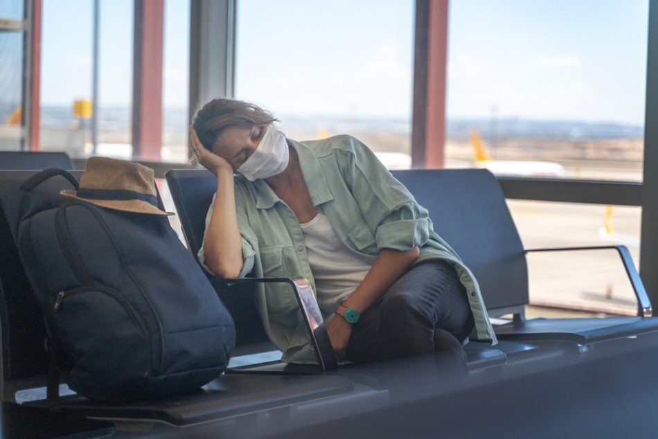 Woman in mask sleeping in airport