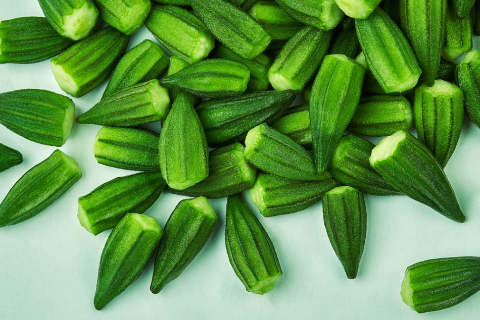 Pile of green okra on a light green background.