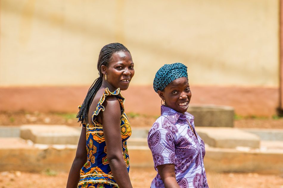 two Benin women look back at camera