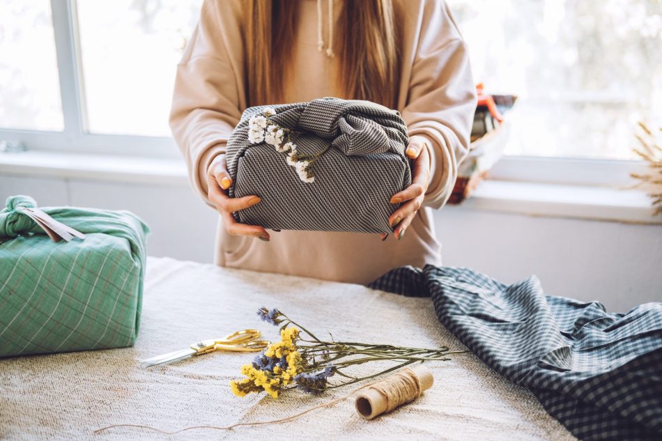 woman wraps gifts with eco-friendly and reusable furoshiki