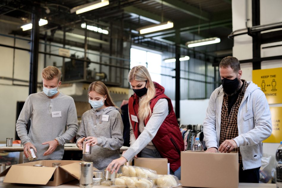 group of volunteers with masks pack donation boxes