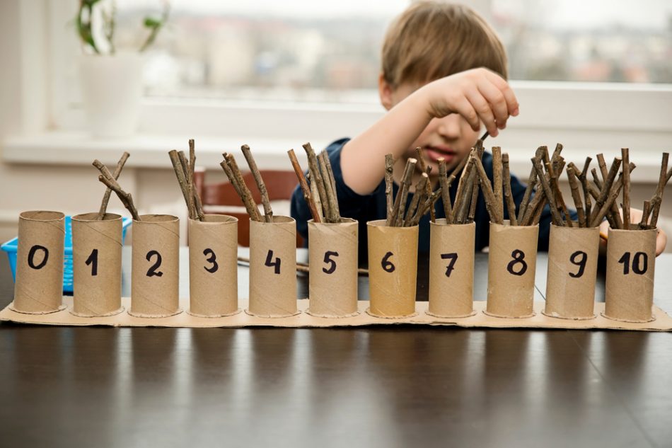 child organizes sticks into numbered cases