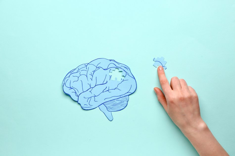 a person points to the missing piece in a blue brain puzzle
