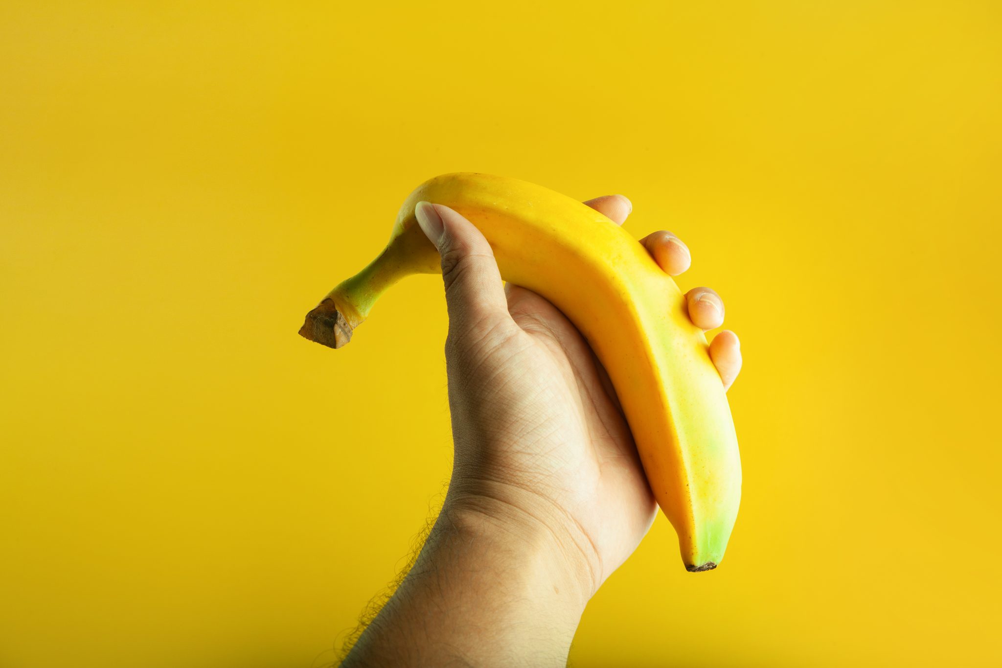 Hand,Holding,Ripe,Banana,In,Yellow,Background | The Optimist Daily ...