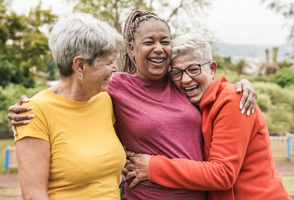 Happy multiracial senior women having fun together outdoors.