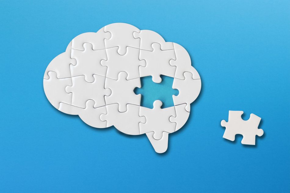 Brain shaped white jigsaw puzzle on blue background, a missing piece of the brain puzzle, mental health and problems with memory.